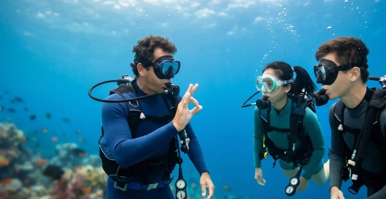 Instructeur de plongée enseignant à un petit groupe sous l'eau avec gestes pédagogiques clairs